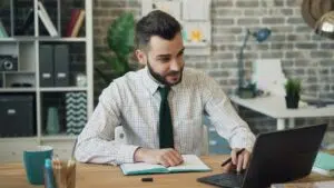 A financial professional works with a laptop and notebook in a modern office, highlighting the essential digital tools enabling specialized accounting support in 2025.