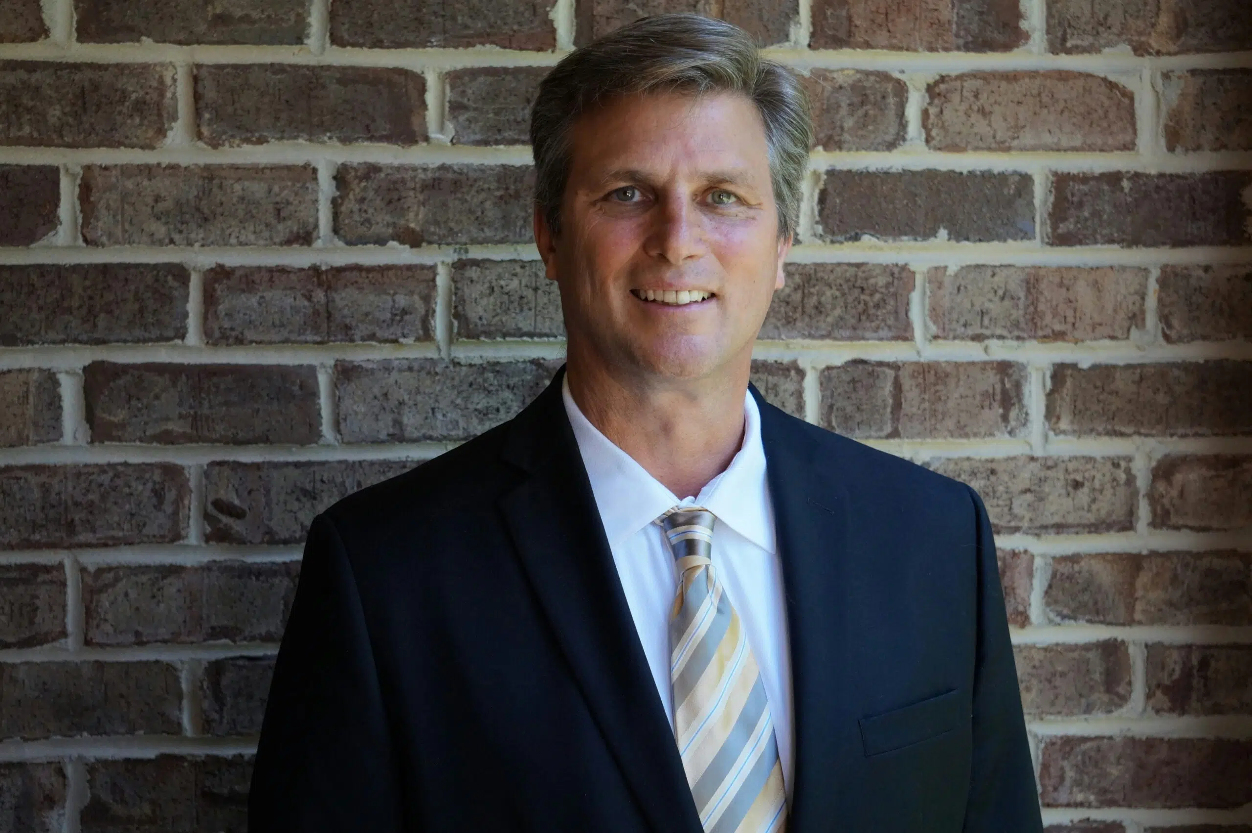 A confident fractional CFO standing infront of a brick wall