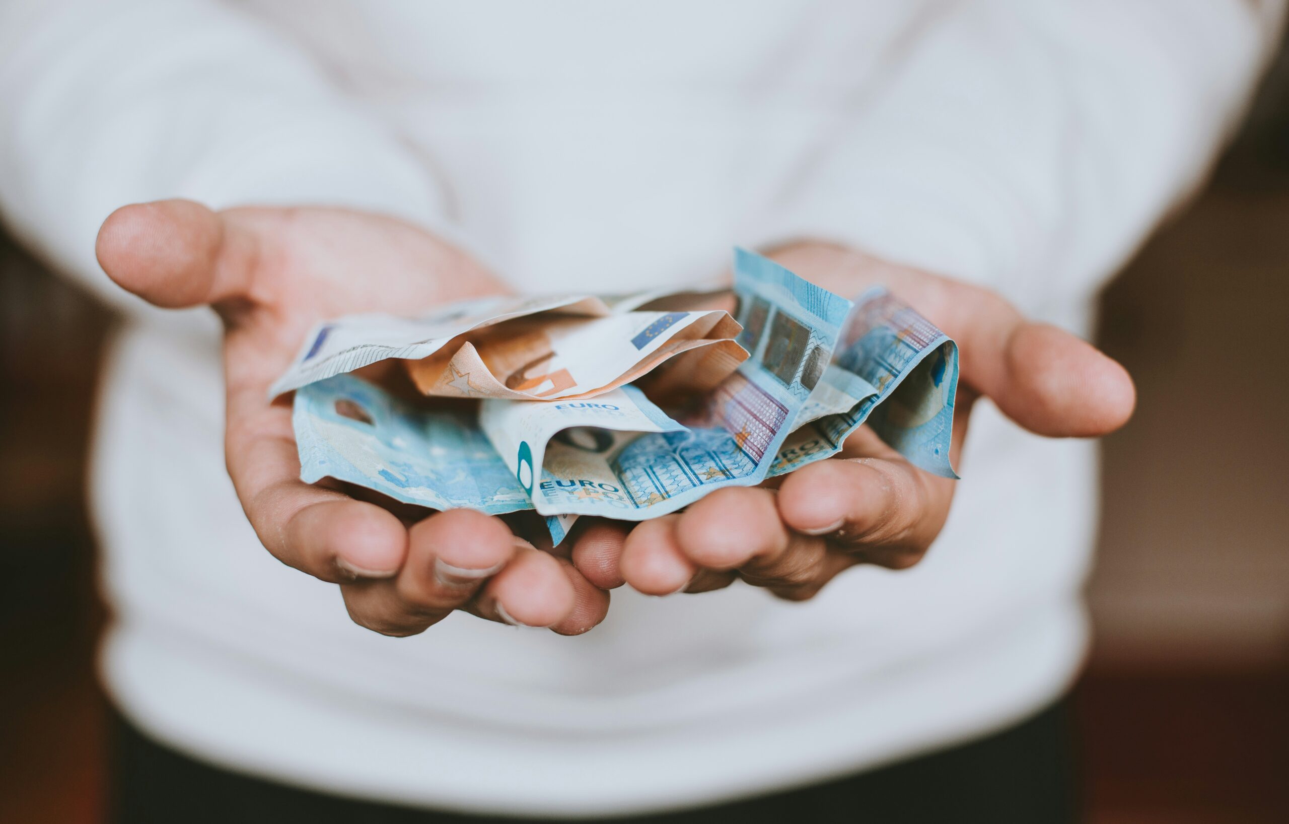 a person holding cash | Cohesion a person holding cash