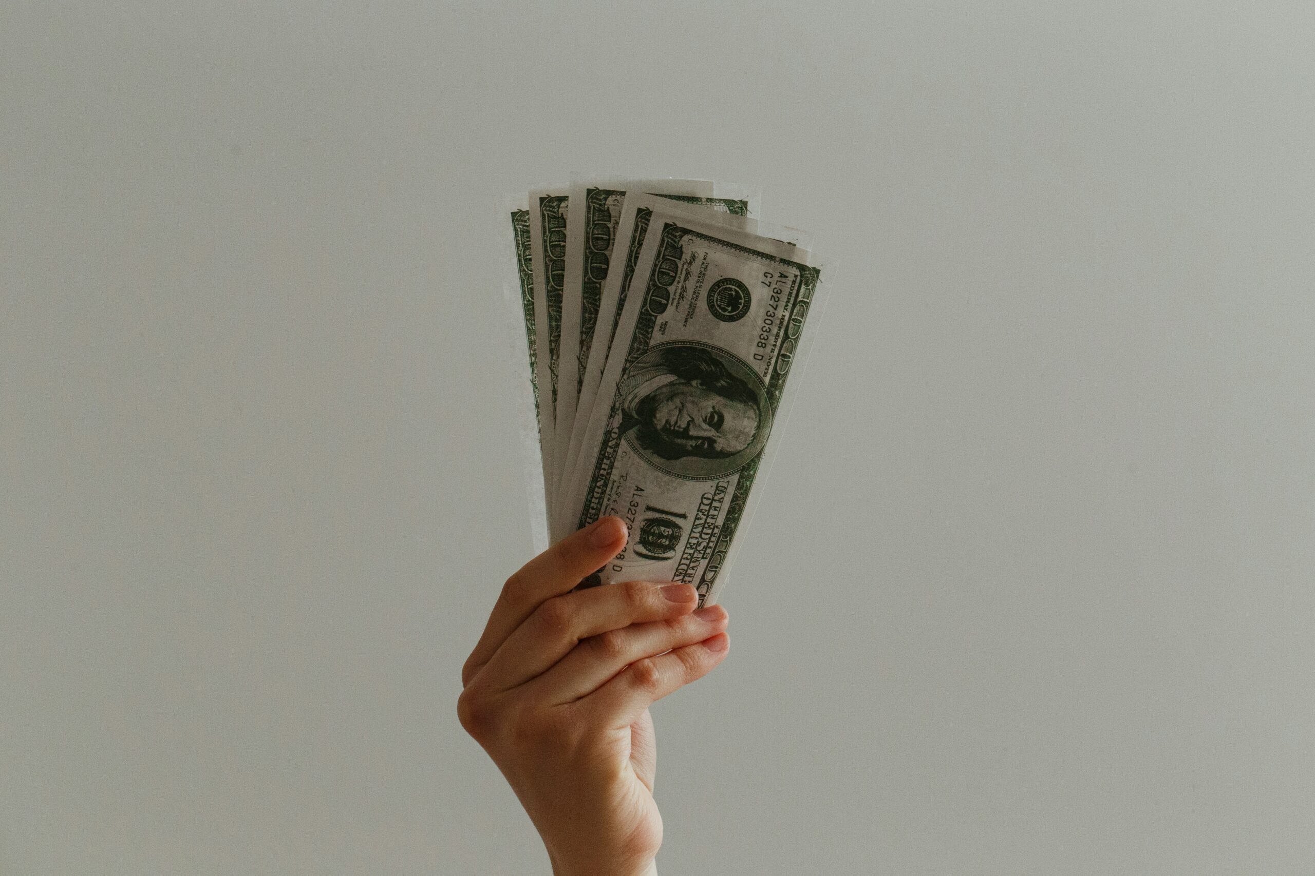 a person holding cash | Cohesion a person holding cash