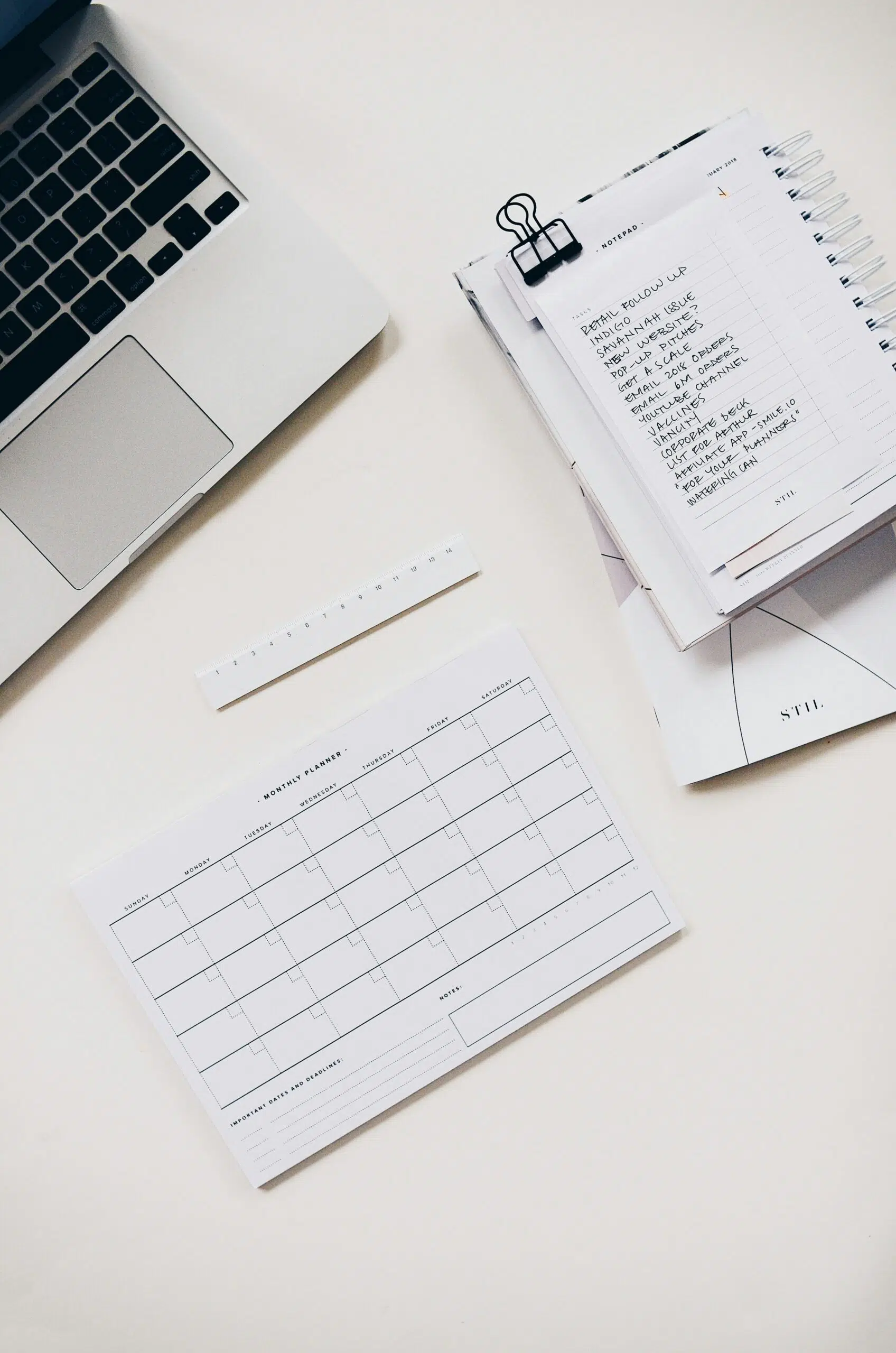 a notepad and a laptop on a desk | Cohesion a notepad and a laptop on a desk