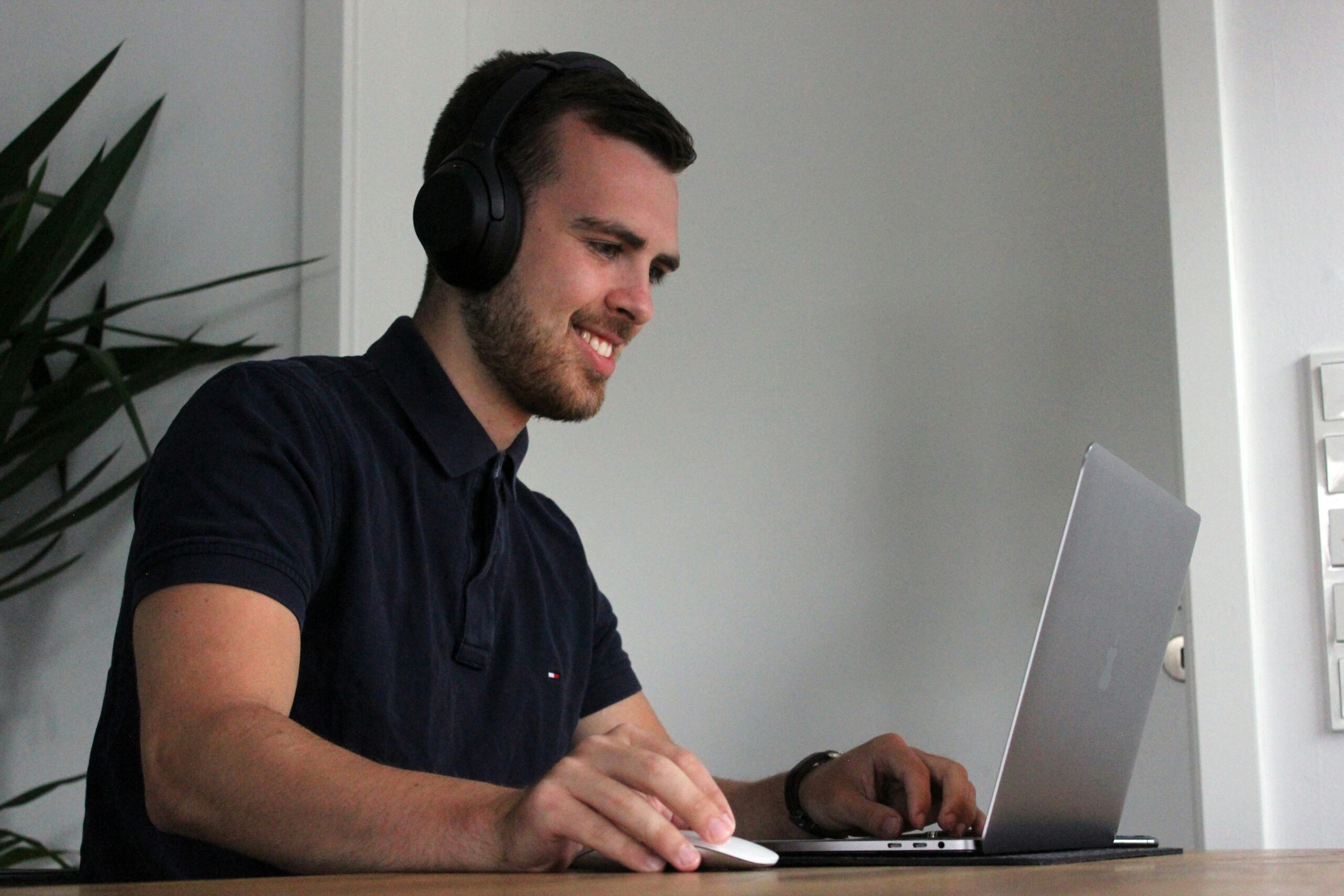 Man in headphones smiling during a virtual meeting on financial planning. | Cohesion Man in headphones smiling during a virtual meeting on financial planning.