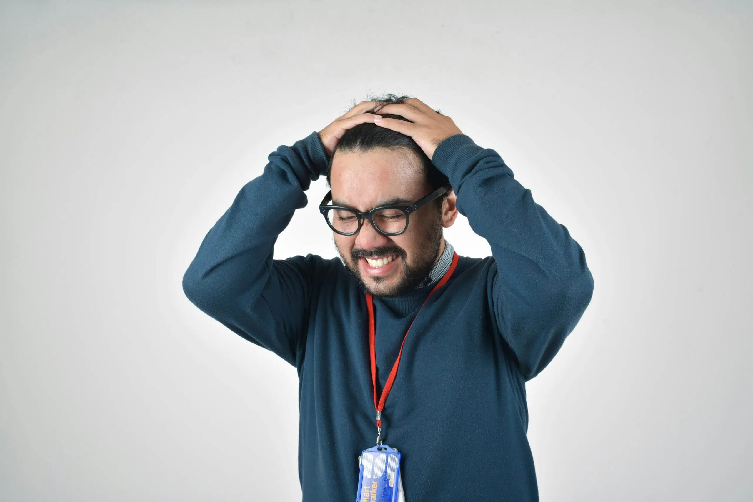 A man in a work badge clutching his head in frustration, representing the stress caused by inaccurate financial reports. | Cohesion A man in a work badge clutching his head in frustration, representing the stress caused by inaccurate financial reports.