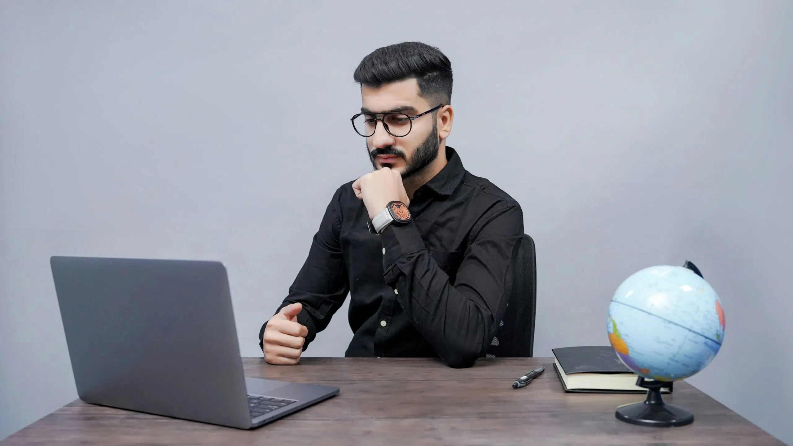 A concerned man staring at his laptop with a thoughtful expression, symbolizing the early signs of financial trouble in a business. | Cohesion A concerned man staring at his laptop with a thoughtful expression, symbolizing the early signs of financial trouble in a business.